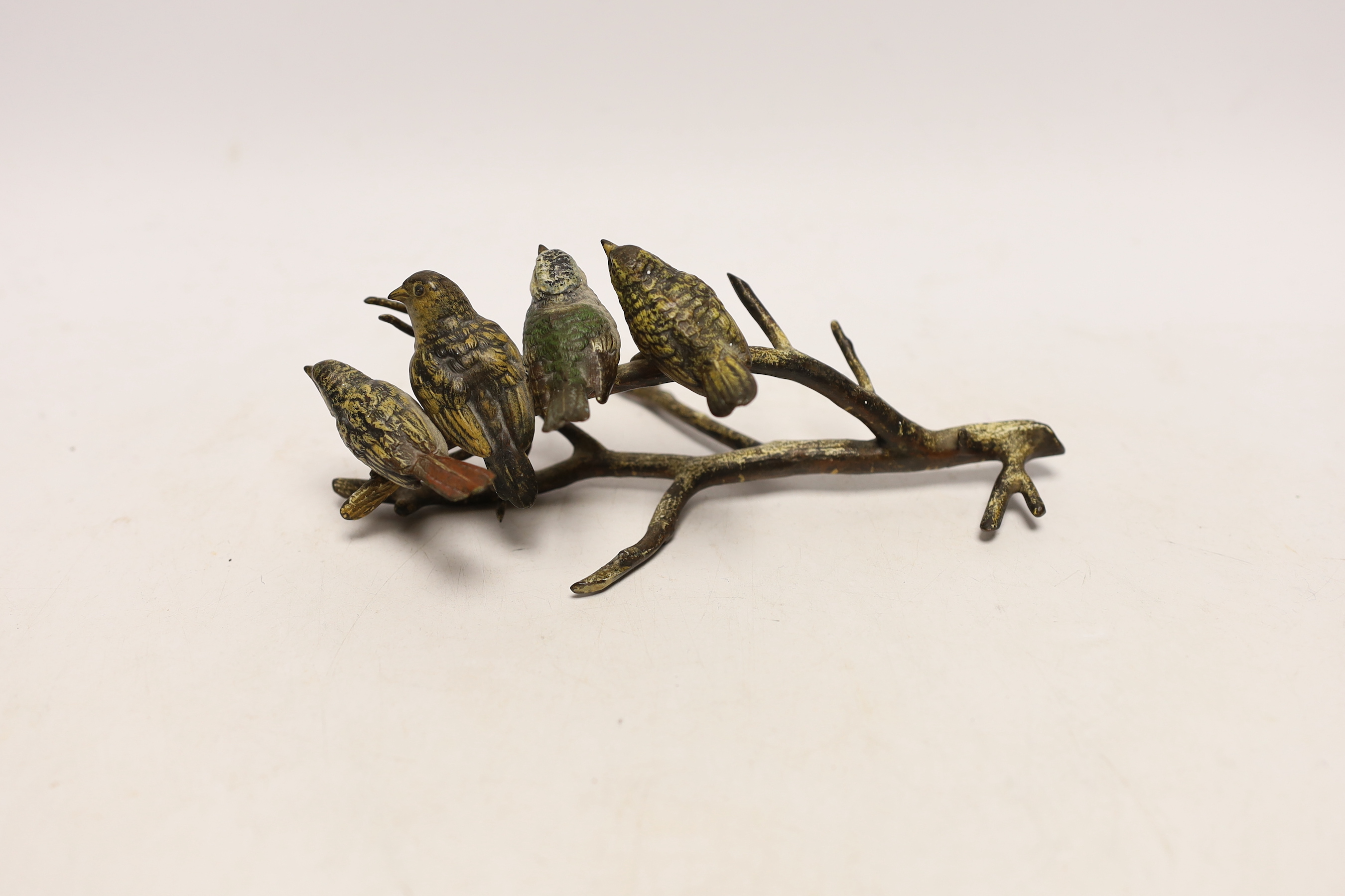 An Austrian cold painted bronze group of four birds on a branch, stamped Geschutz, 19cm long